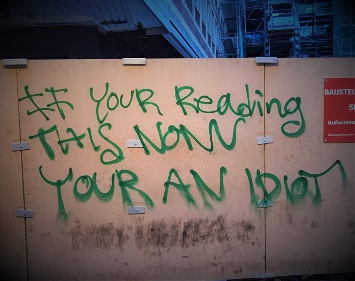 Graffiti with grammar mistakes. It reads wrongly 'if your reading this now your an idiot' when your should be you're